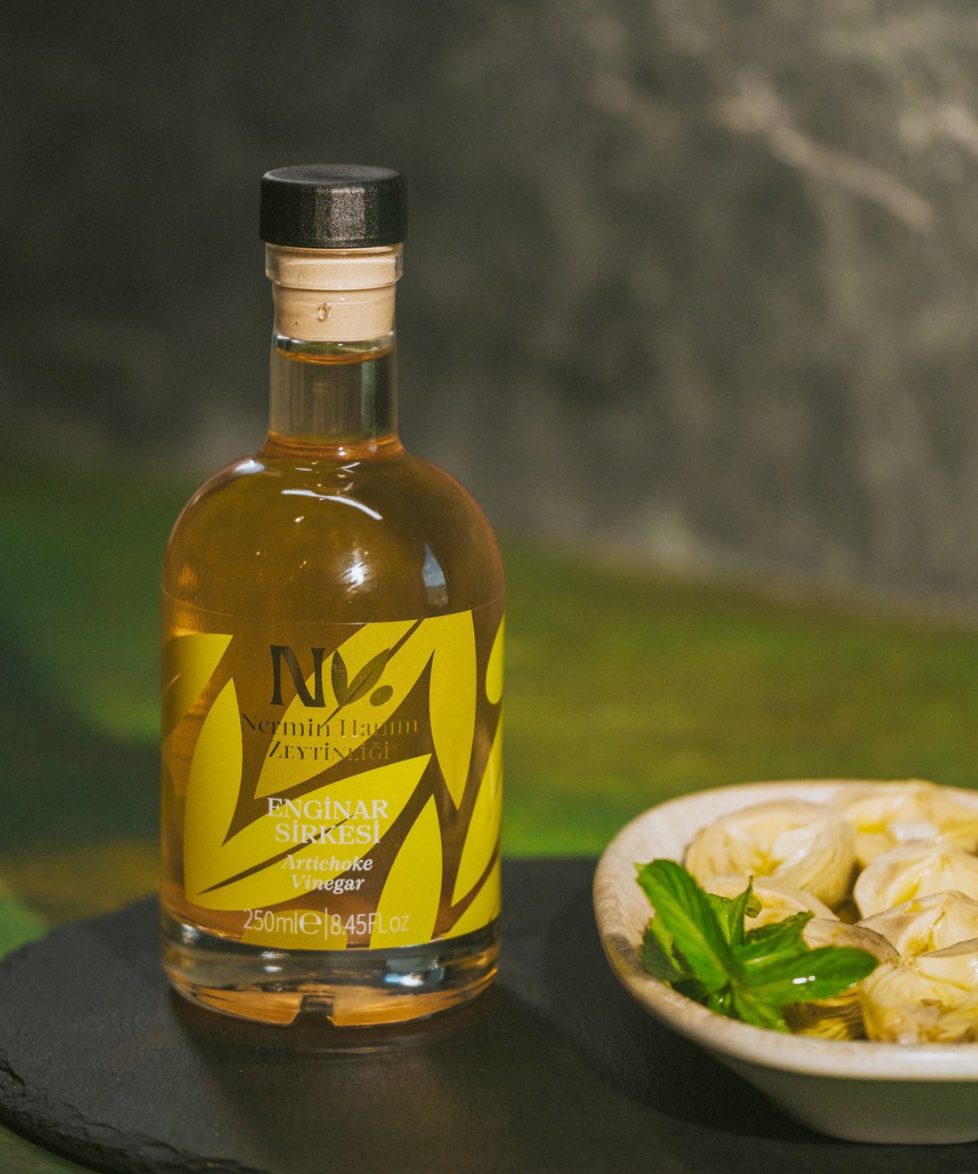 Nermin artichoke vinegar bottle beside an artichoke dish
