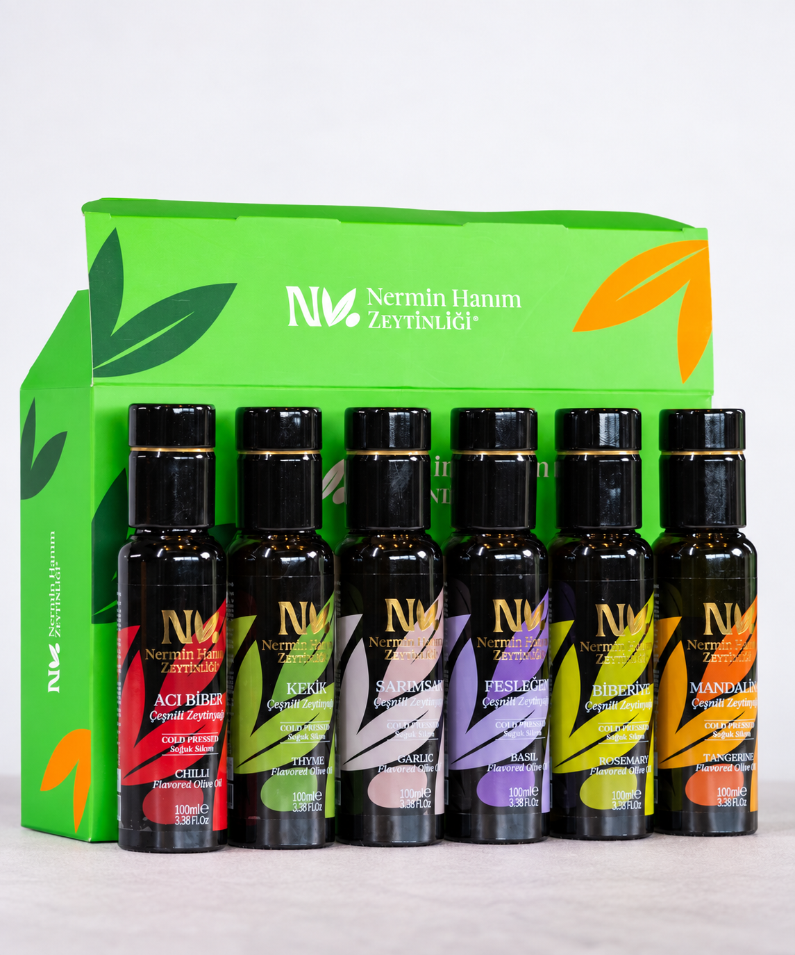 Nermin mini flavored olive oil bottles displayed in front of a green gift bag
