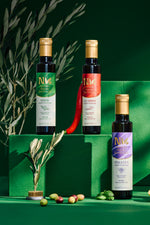 Nermin thyme, chili and basil flavored olive oil bottles on green display blocks