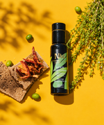 Nermin thyme flavored olive oil beside bread, olives and thyme