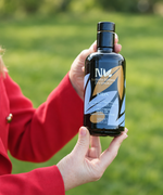 Hands holding a Nermin Kids olive oil bottle outdoors
