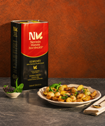 Nermin Everyday Edremit olive oil tin beside a plate of vegetables